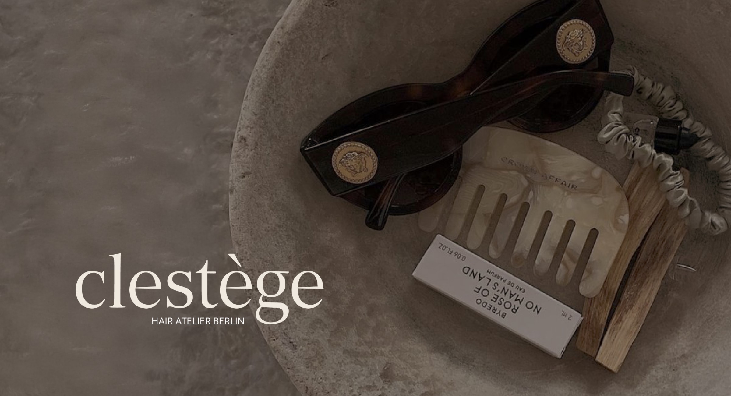 Clestège branded flat-lay — tortoiseshell sunglasses, hair clip and product in a stone bowl with the clestège wordmark